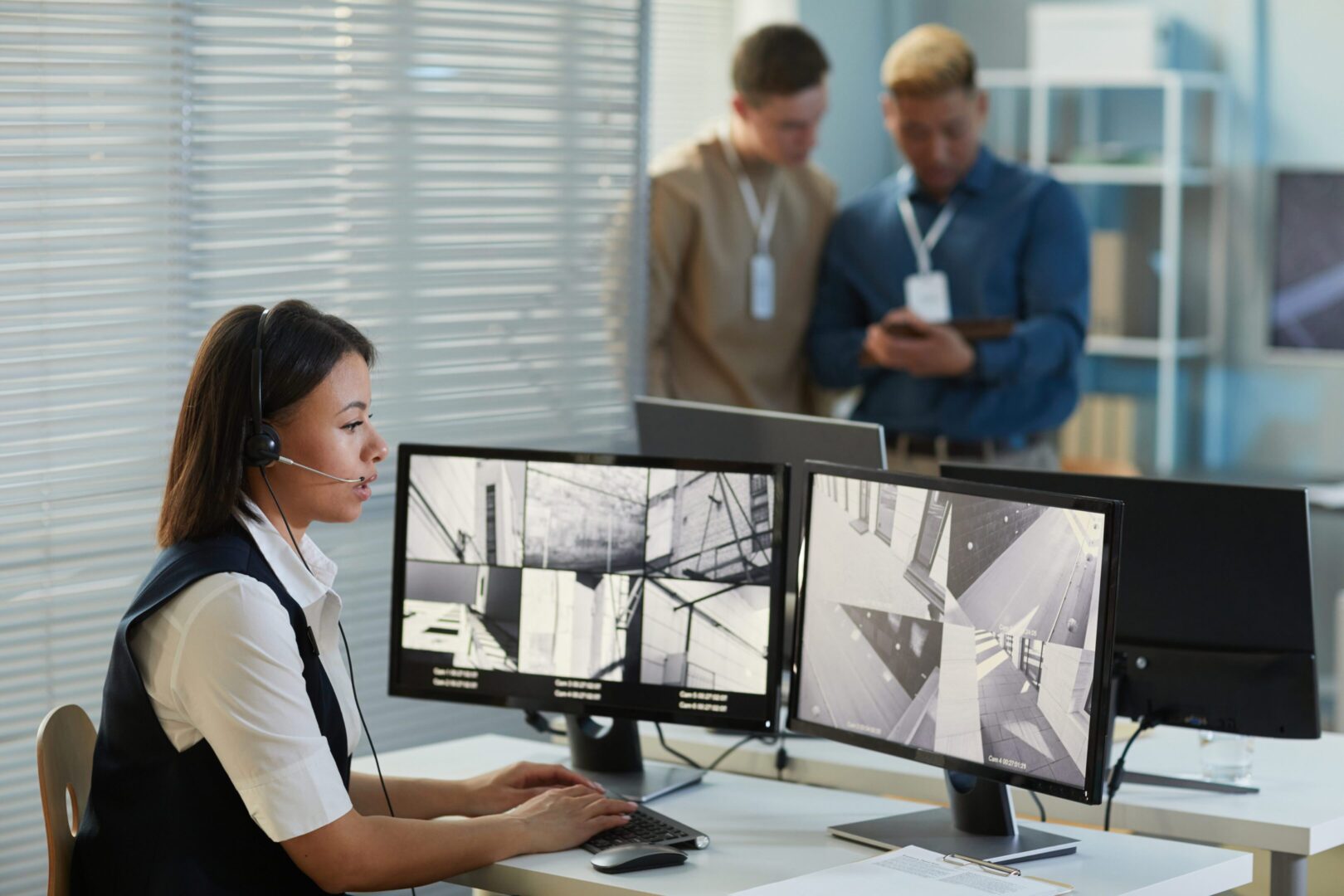 Missing person investigator monitors surveillance feeds at a security desk.